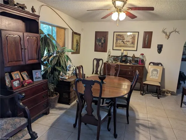 Dining room featuring light tile patterned flooring, ceiling fan, and a textured ceiling