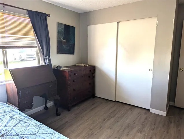 Bedroom with a closet, wood-type flooring, and a textured ceiling
