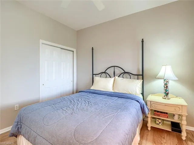 Bedroom with light wood-style floors, a ceiling fan, and a closet