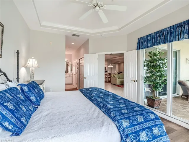 Bedroom featuring access to exterior, wood finished floors, a ceiling fan, and connected bathroom