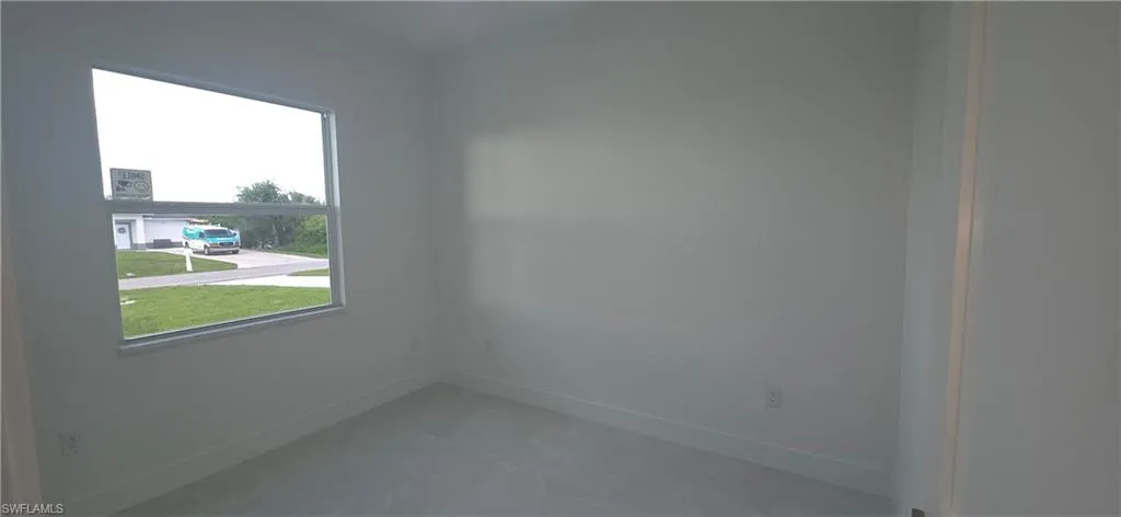 Interior room featuring light-toned walls, a single-pane window, and light-toned flooring