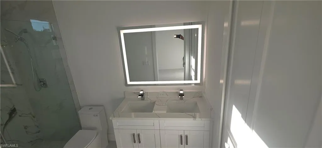 Contemporary vanity with dual integrated sinks and polished chrome fixtures