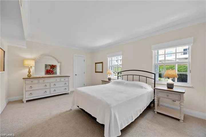 Bedroom featuring light colored carpet and crown molding