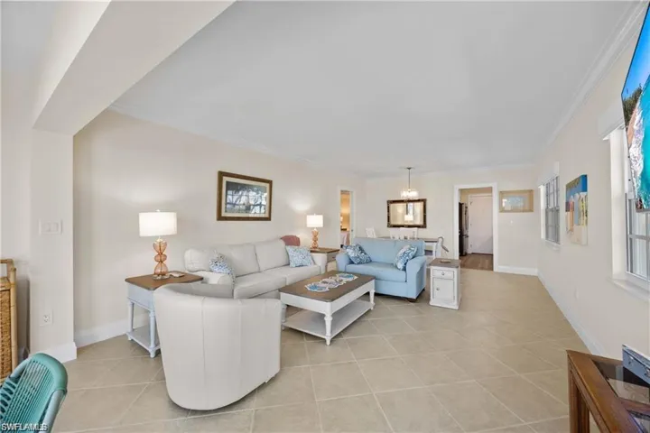 Living area featuring light tile patterned flooring and ornamental molding