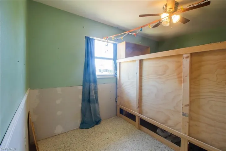 Unfurnished bedroom featuring speckled floor and a ceiling fan