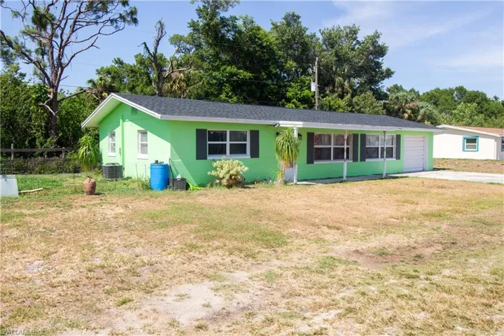 Single story home with a front lawn, driveway, and central AC