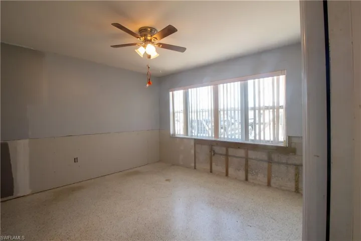 Empty room with speckled floor and ceiling fan