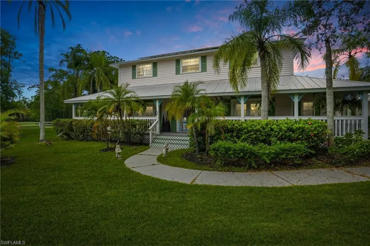 View of front of home featuring a yard and a porch - Virtually Edited Image