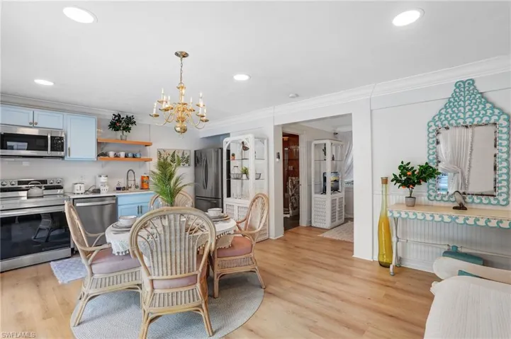Dining area with light wood finished floors, a chandelier, recessed lighting, and crown molding - Virtually Edited Image