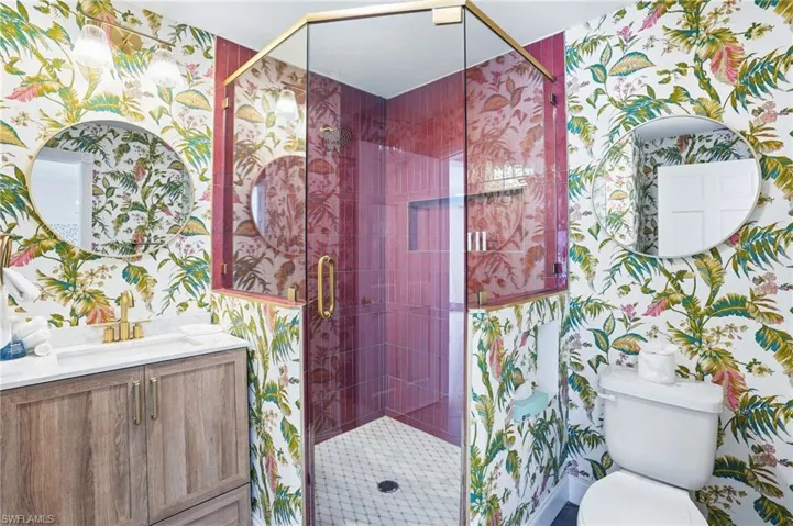 Full bathroom with wallpapered walls, vanity, and a shower stall - Virtually Edited Image