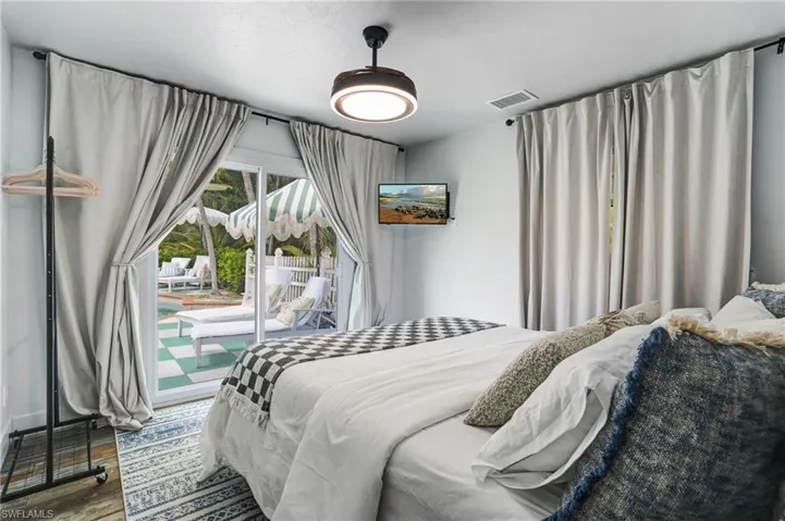 Bedroom featuring wood finished floors and access to exterior - Virtually Edited Image