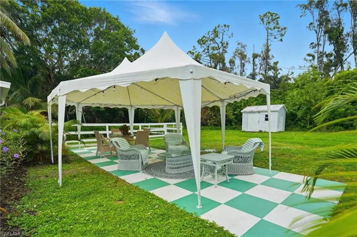 View of home's community with a storage shed, a patio area, a lawn, and a gazebo - Virtually Edited Image