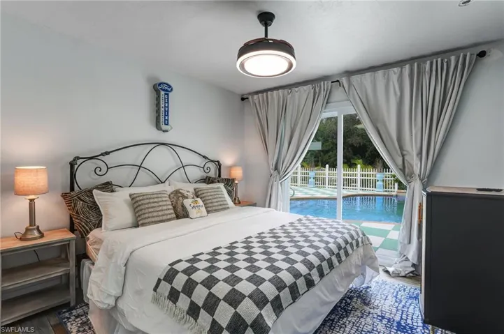 Bedroom featuring wood finished floors and access to exterior - Virtually Edited Image