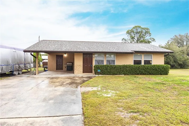 Ranch-style house with a front lawn and a carport