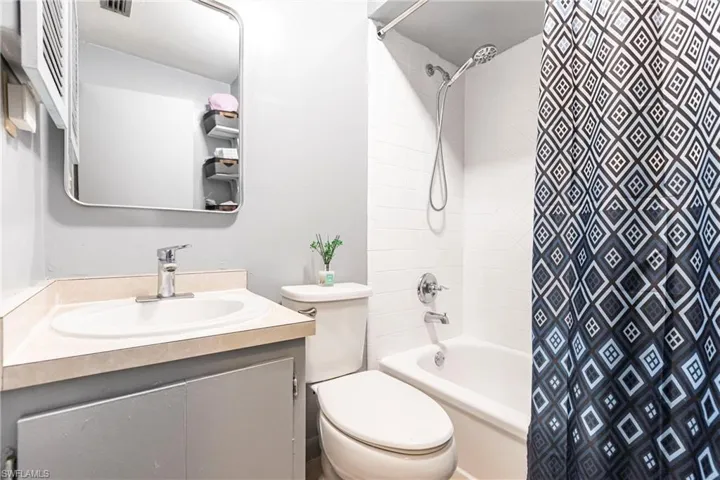 Full bathroom featuring shower / bath combo with shower curtain, toilet, and vanity