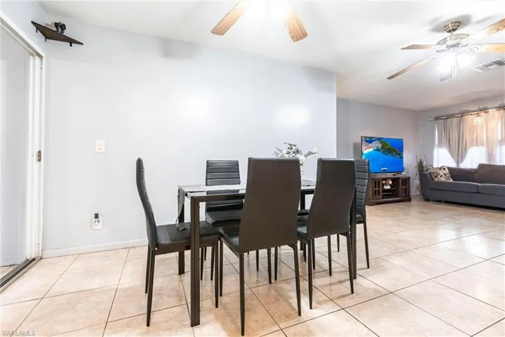 Dining room with light tile patterned floors and ceiling fan