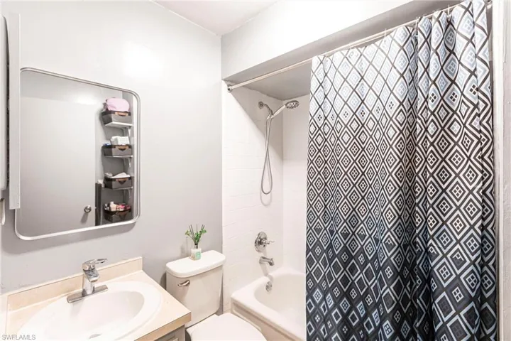 Full bathroom featuring toilet, vanity, and shower / tub combo