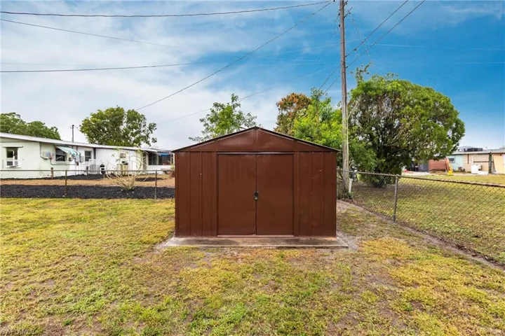 View of outbuilding with a lawn