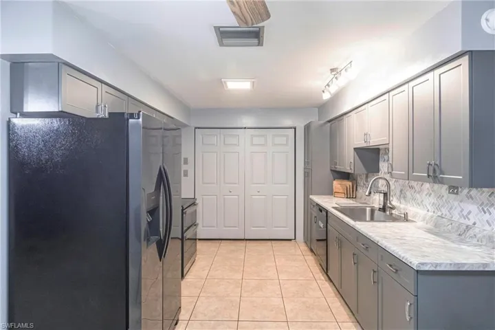Kitchen featuring sink, gray cabinets, and stainless steel fridge