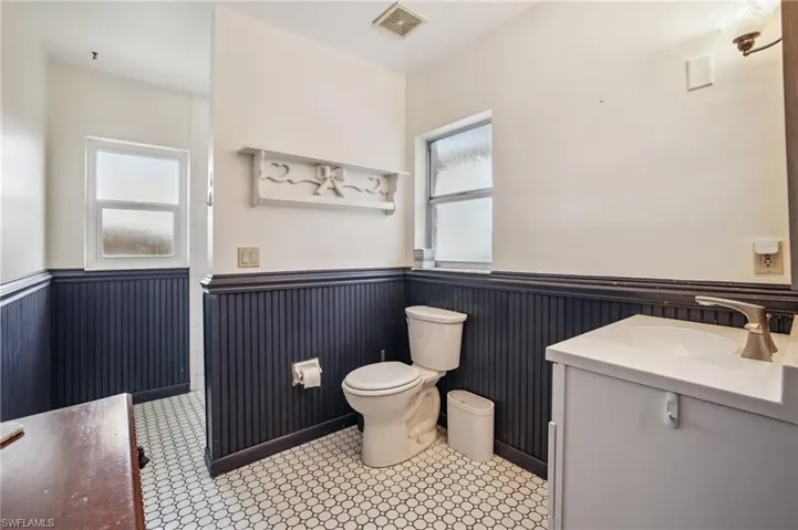 Half bathroom with wainscoting and vanity