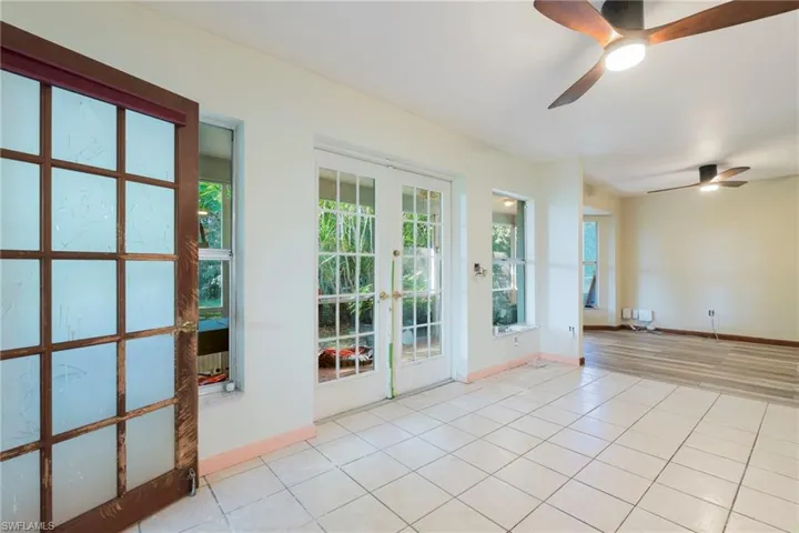 Unfurnished room with light tile patterned floors, french doors, and ceiling fan