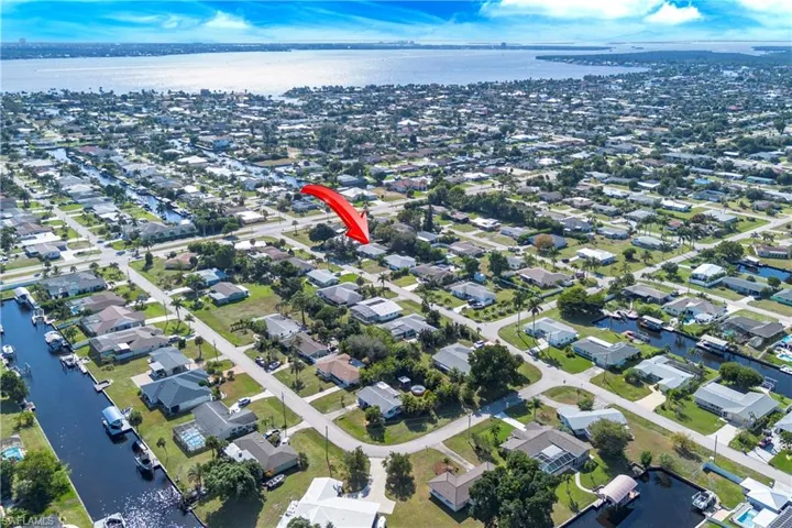 Aerial view of property's location with a large body of water and nearby suburban area