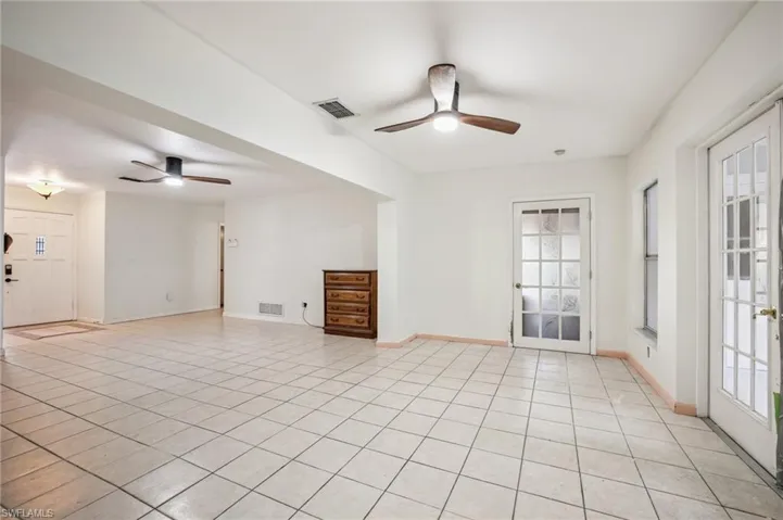Unfurnished living room with a ceiling fan and light tile patterned floors