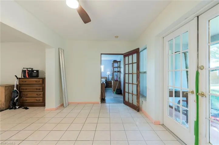 Unfurnished room with french doors, ceiling fan, and light tile patterned flooring