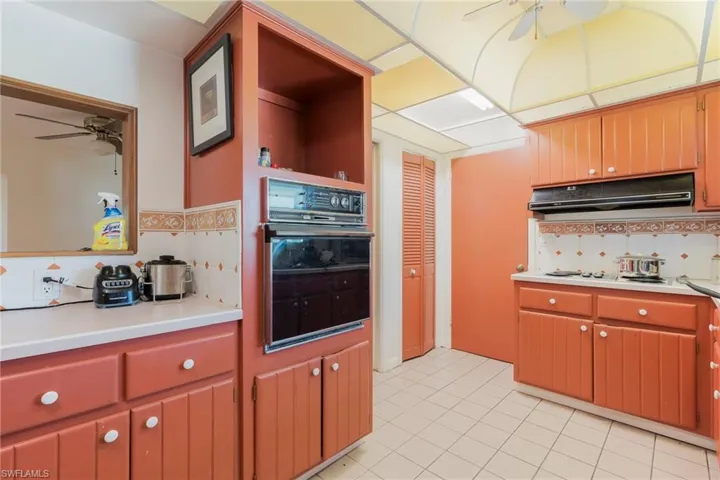 Kitchen featuring a ceiling fan, tasteful backsplash, open shelves, oven, and light countertops