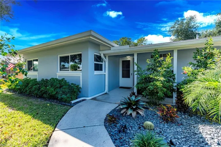 Doorway to property with stucco siding and a yard