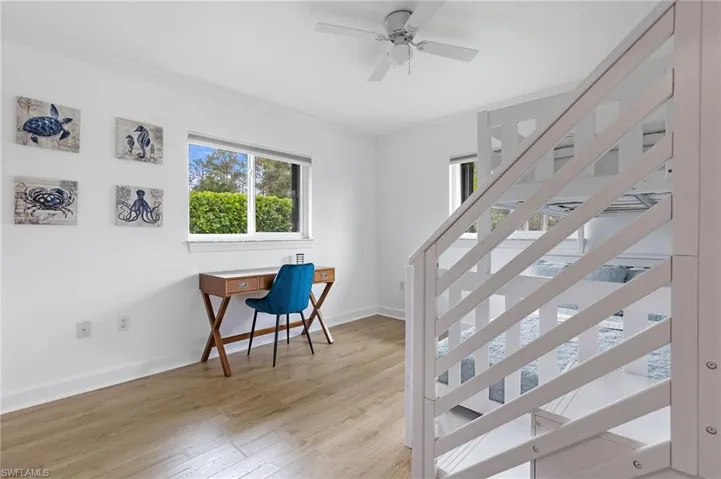 Staircase featuring hardwood / wood-style floors, ceiling fan, and ornamental molding