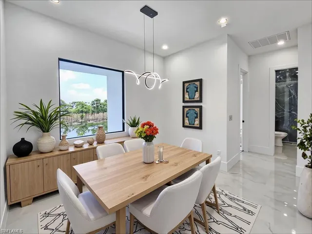 Dining area with a large picture window, a linear modern pendant light fixture, and recessed lighting