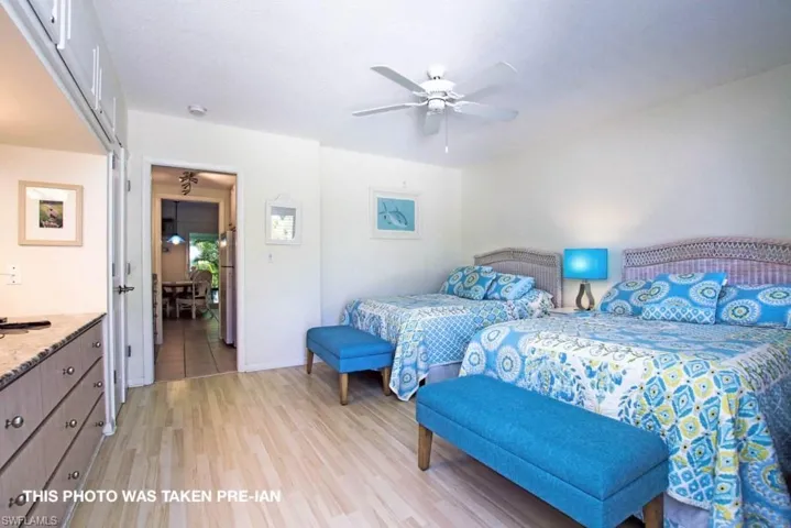 Bedroom with ceiling fan, light hardwood / wood-style flooring, and stainless steel refrigerator