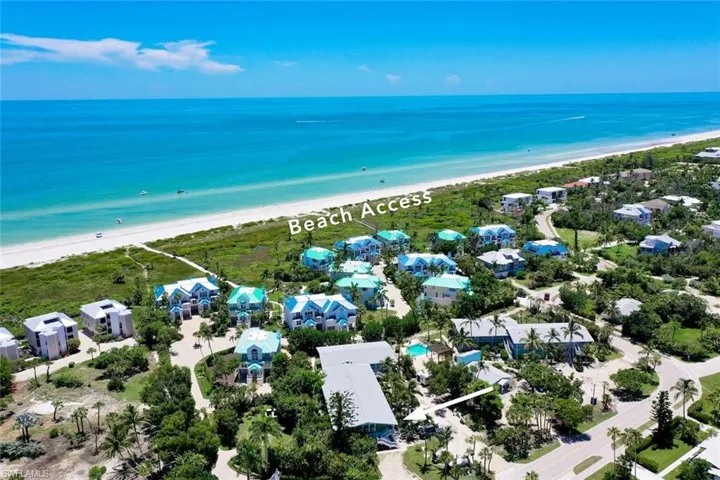 Birds eye view of property featuring a water view and a beach view