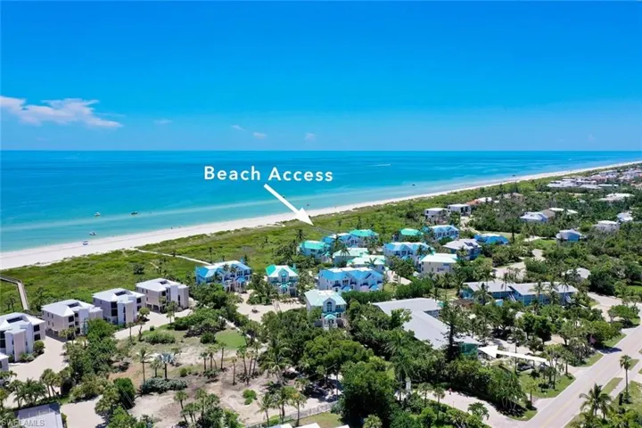 Birds eye view of property featuring a water view and a view of the beach