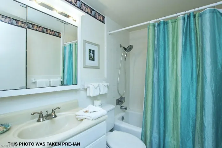 Full bathroom with shower / tub combo with curtain, vanity, and toilet