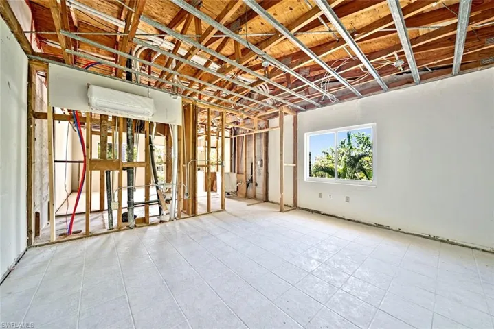 Misc room with a wall mounted air conditioner and light tile patterned floors