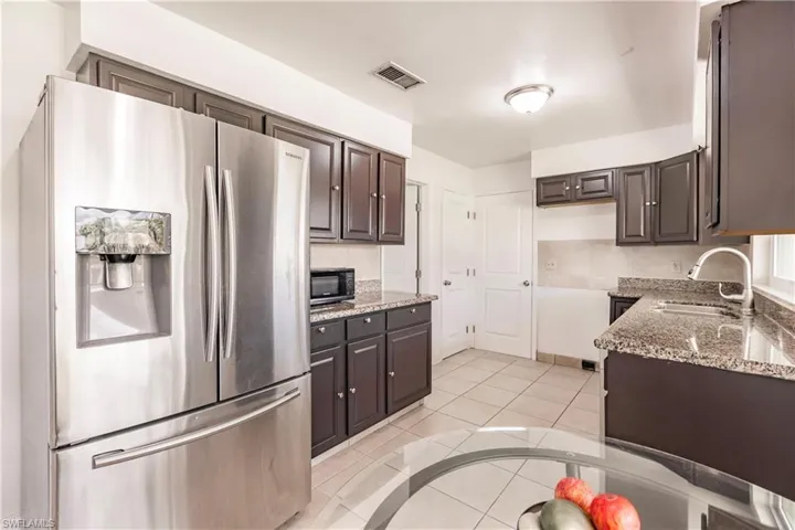 Freshly painted cabinets with Granite countertops and stainless fridge