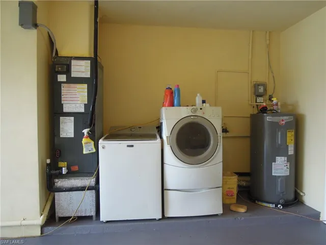 Laundry room with water heater, Washer, Dryer and newer AC unit