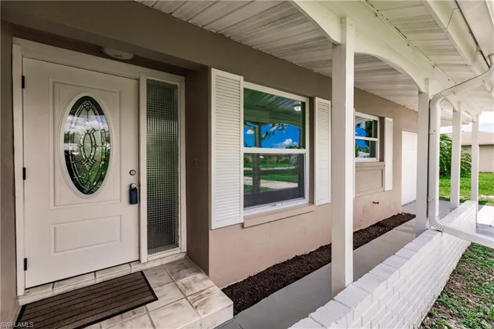 View of exterior entry with covered porch