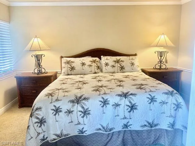 Bedroom with baseboards, ornamental molding, and carpet