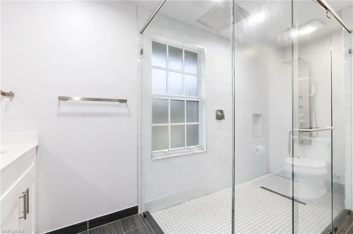 Bathroom featuring vanity, toilet, and walk in shower