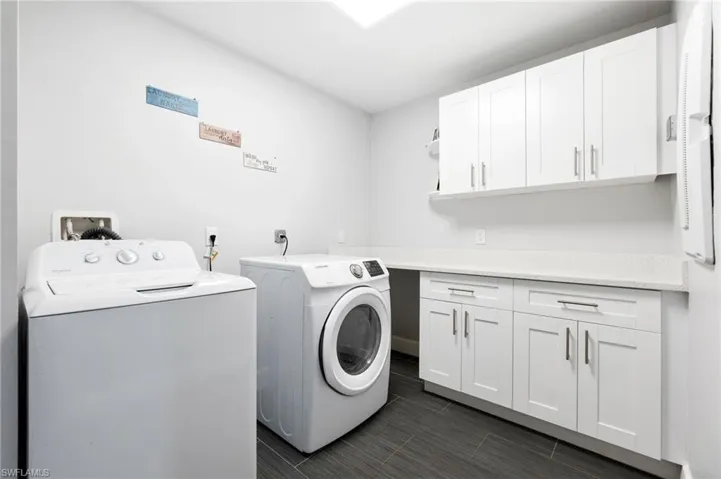 Laundry room featuring cabinets and separate washer and dryer