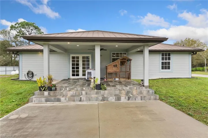 Back of property with french doors, ceiling fan, and a lawn