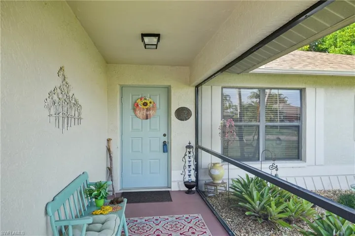Property entrance featuring stucco siding and a shingled roof