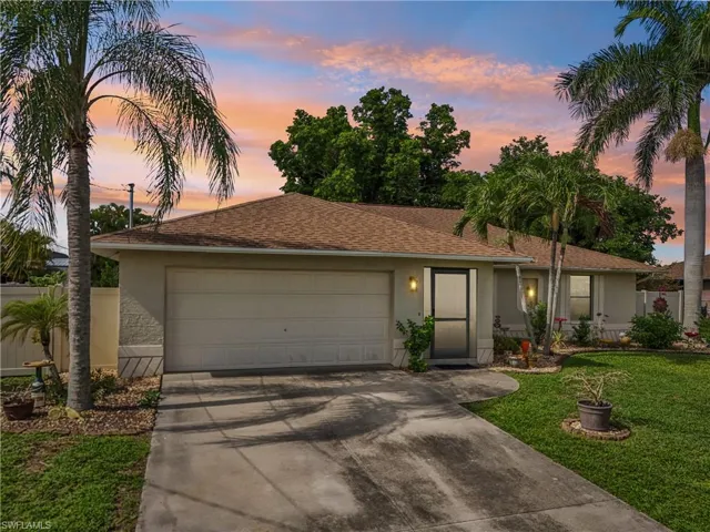 Single story home with stucco siding, concrete driveway, a garage, and a shingled roof