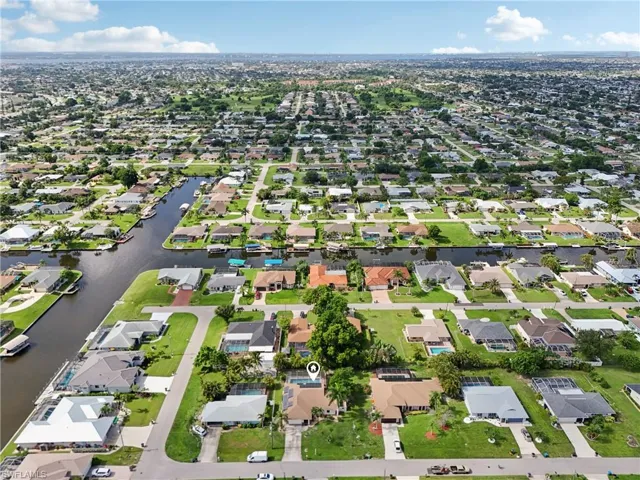 Aerial view of property and surrounding area featuring nearby suburban area and a nearby body of water