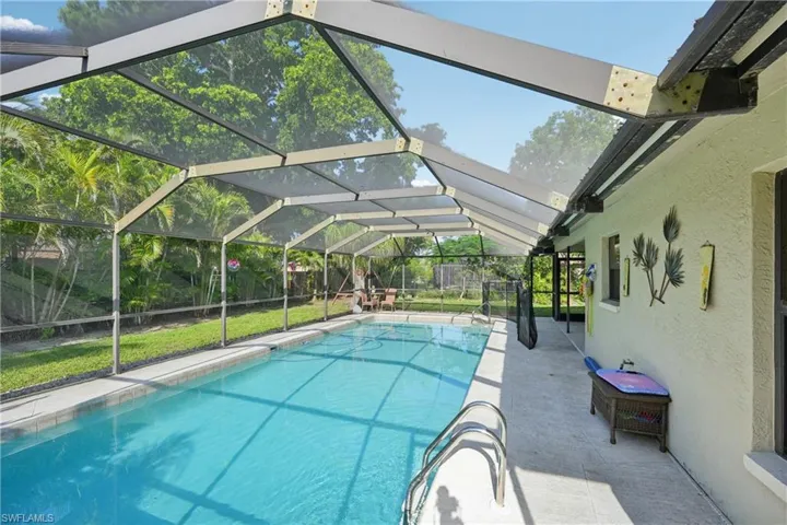 Outdoor pool featuring glass enclosure and a patio area