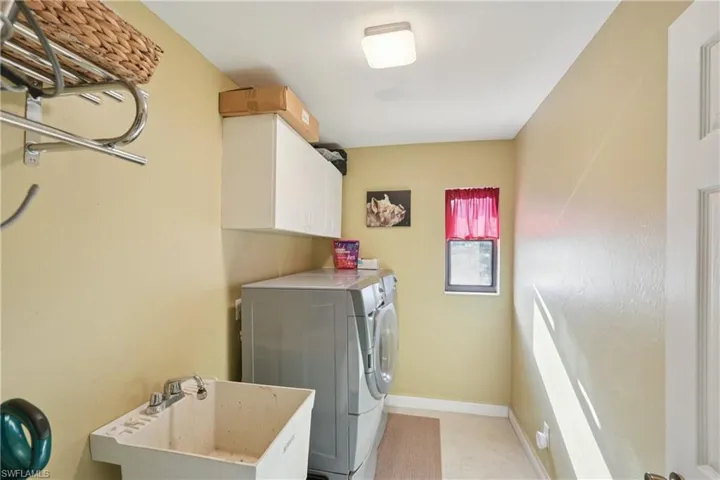 Laundry room with cabinet space, independent washer and dryer, and light tile patterned flooring