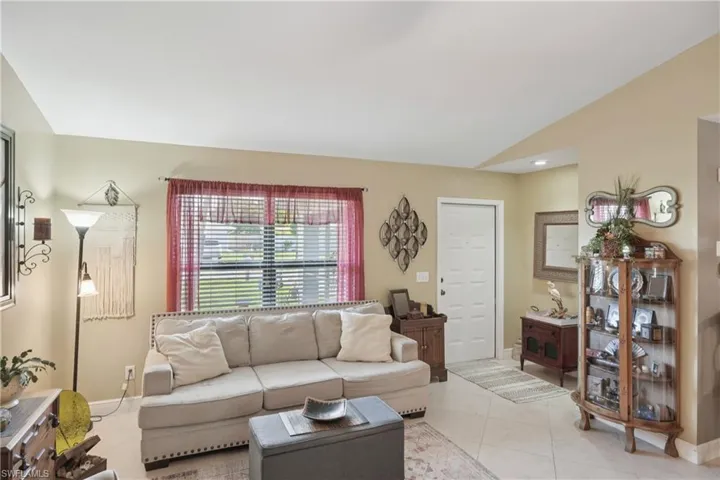 Living area with lofted ceiling and light tile patterned flooring